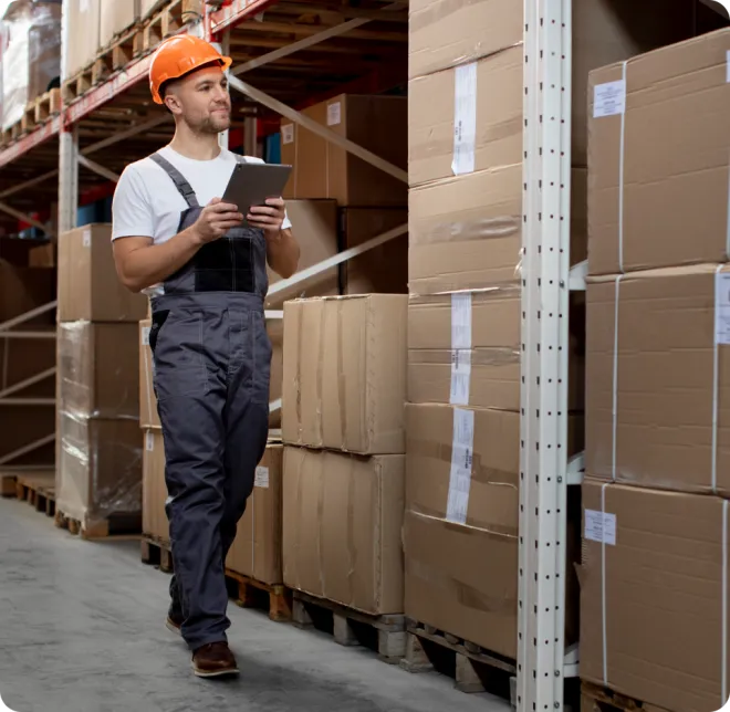 Man in a hard hat counting boxes.