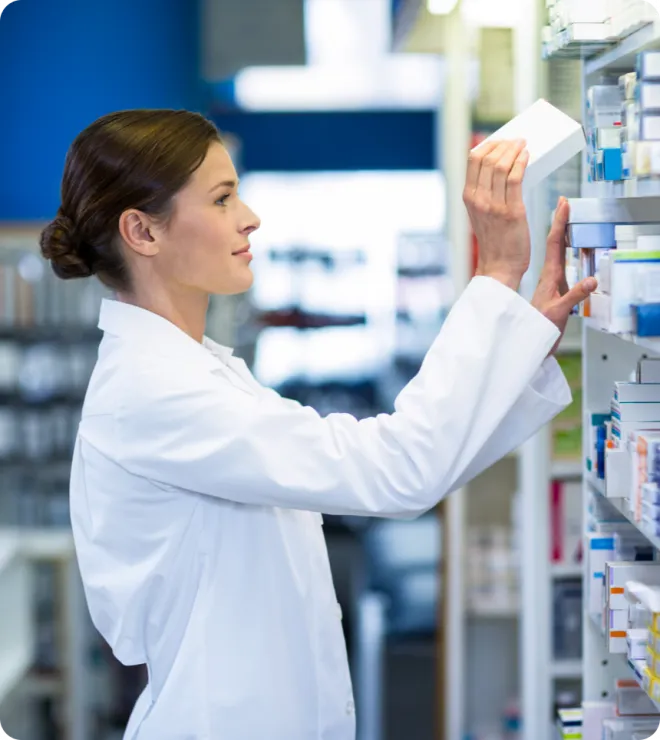 Female pharmacist stocking medicine.