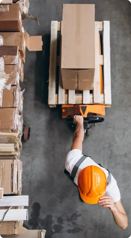 Man in a warehouse pulling a pallet.