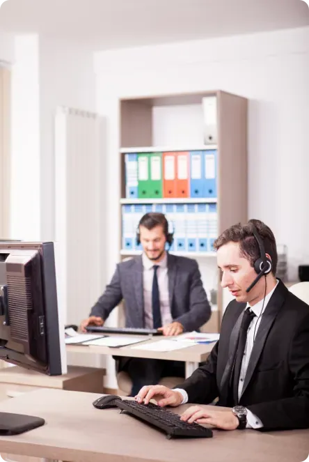 Two men with headsets on the phone.
