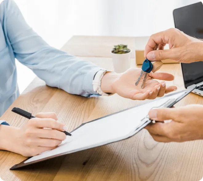 Man handing a woman keys to a house.