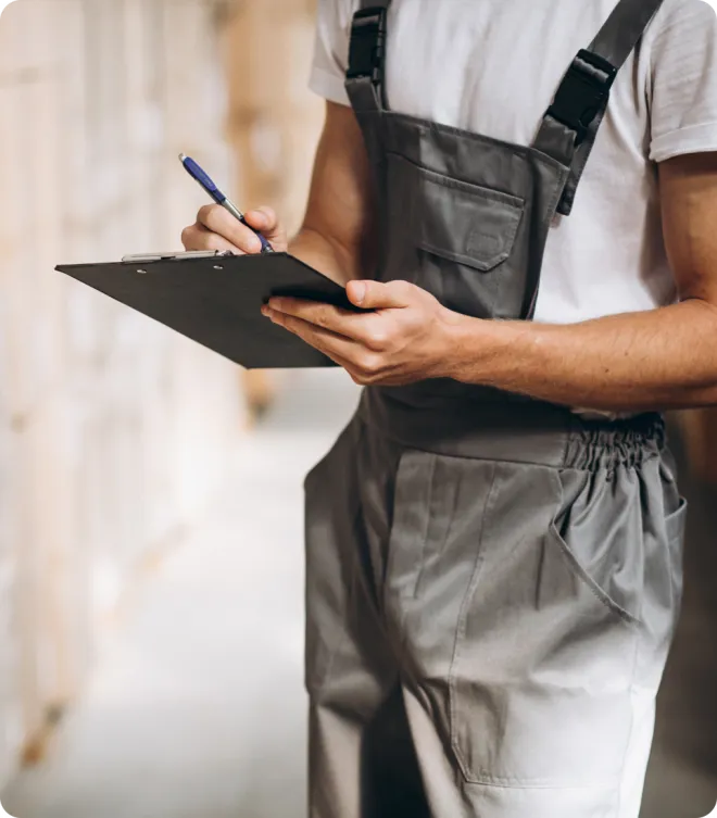 Man in overalls with a clipboard.