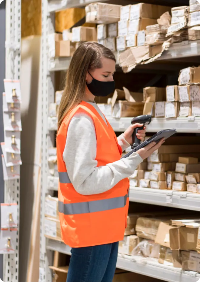 Women in orange PPE using a tablet.