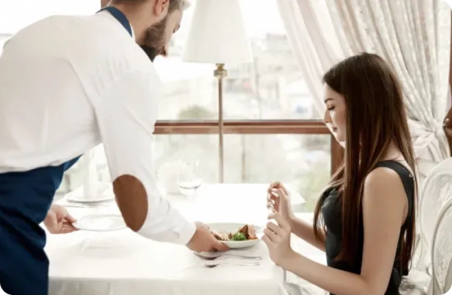 Waiter serving a woman food.