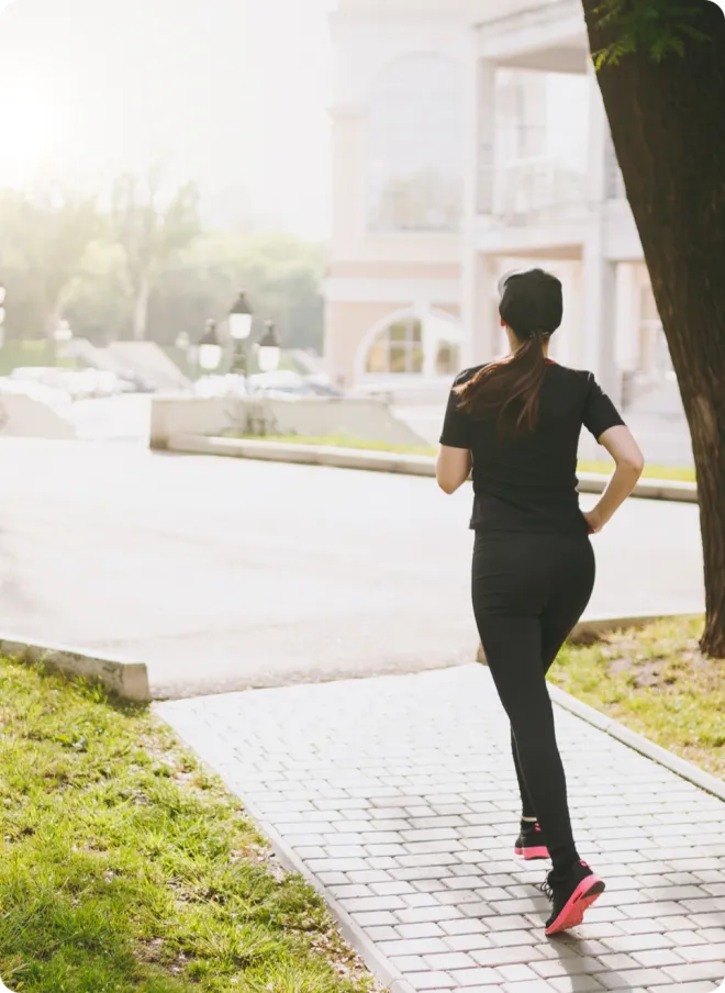 Woman running alone on brick pavement.