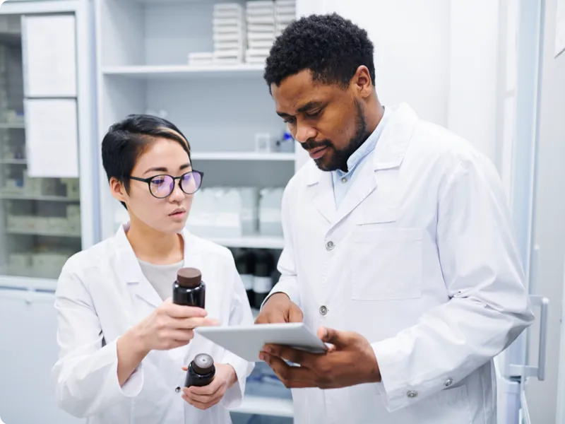 Two pharmacy technicians discuss medications.