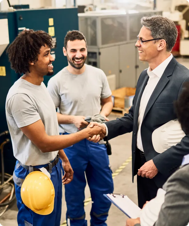 3 men smiling and shaking hands.