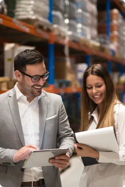 A man and a woman in a warehouse laughing.