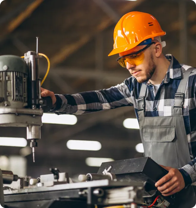 Man using a drill wearing PPE.
