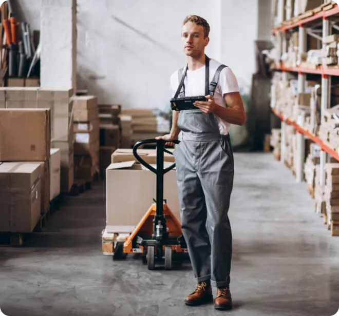 Man in a warehouse pulling a pallet.