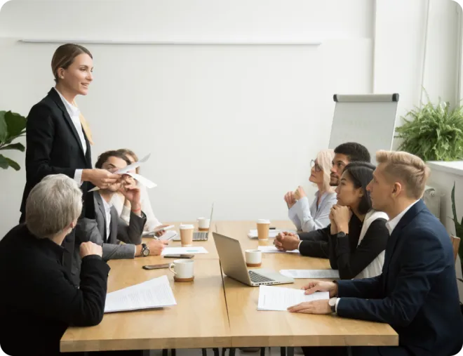 Woman presenting at a conference table.