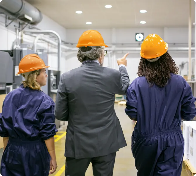 Coworkers in a warehouse wearing orange PPE.