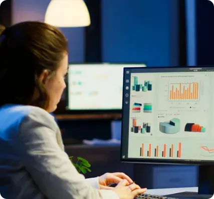Woman looking at charts on a computer screen.
