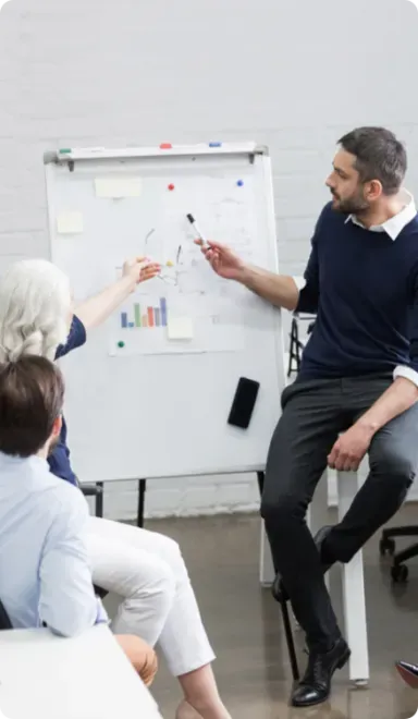Man and woman collaborating on a white board.