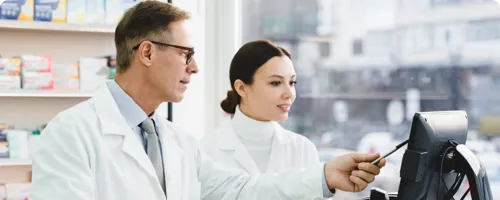 Two pharmacists looking at a computer screen.