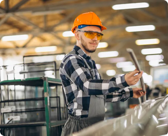 Man and woman in a warehouse wearing orange PPE.