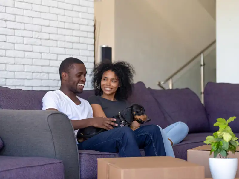 people sitting on the couch with their dog