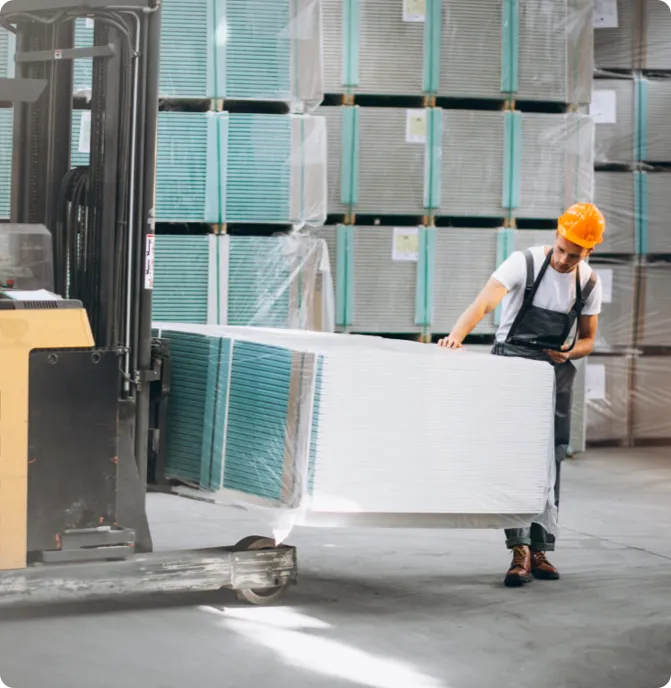 Man in a warehouse using a forklift.