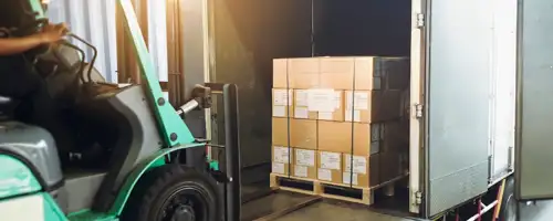 Forklift picking up boxes in warehouse