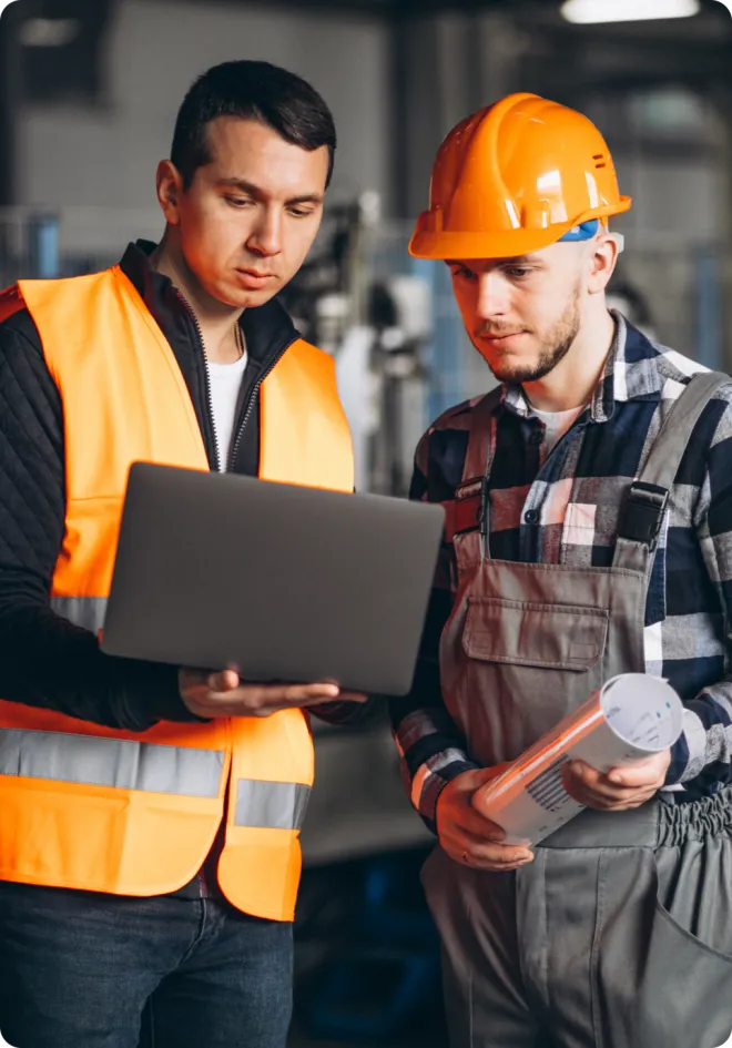 Men in orange PPE using a laptop.