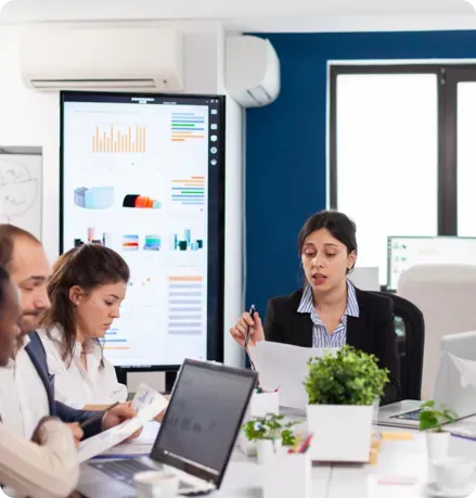 Workers using a computer at a conference table.