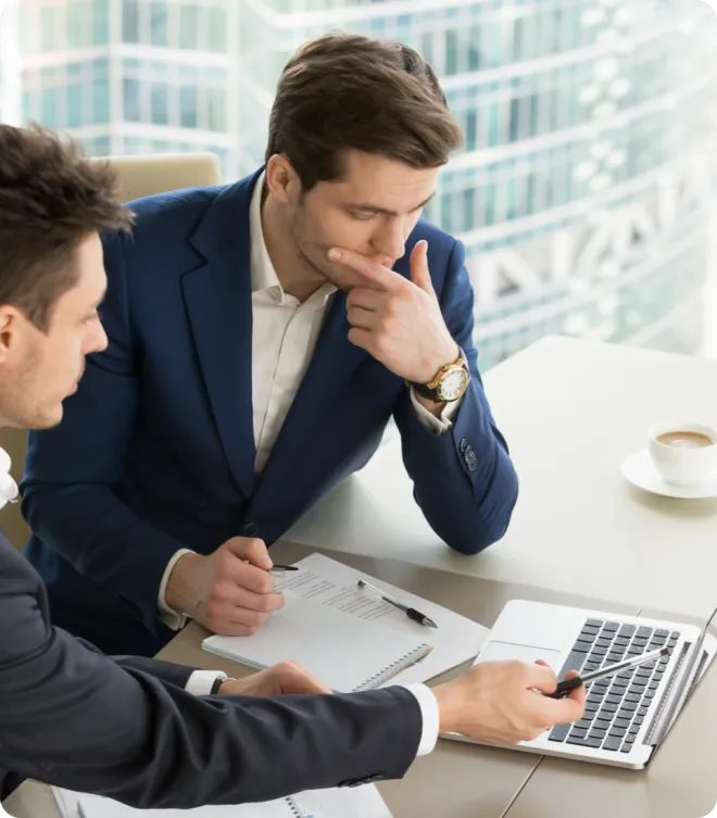 Two men using laptops in an office.