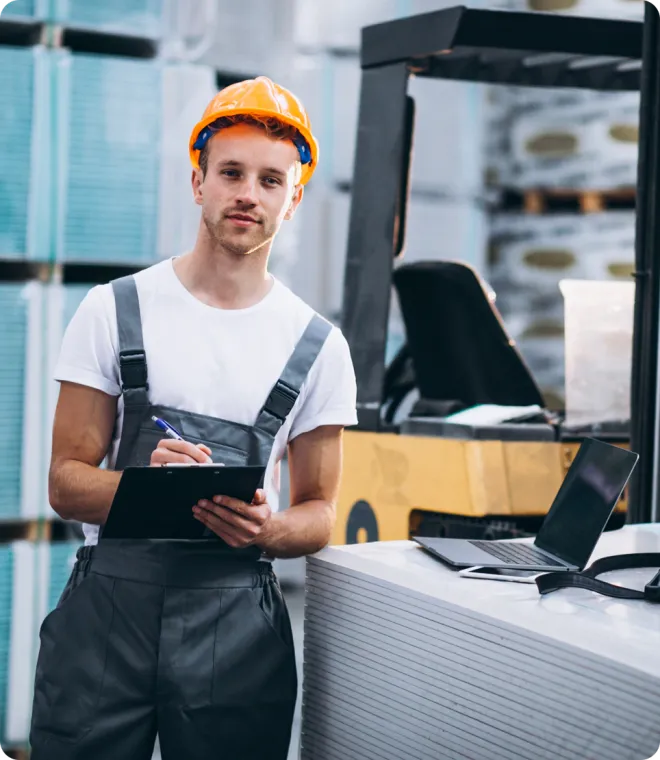 Man and woman in a warehouse wearing orange PPE.